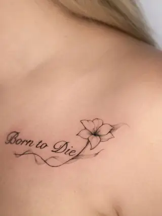 Napis „Born to Die” z kwiatem lilii i falującą linią z cieniem pod obojczykiem – tatuaż Oli, SHADY TATTOO Wieluń