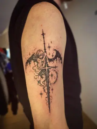 Tatuaż miecza ze skrzydłami, półksiężycem i gwiazdami na ramieniu, czarny tusz – SHADY TATTOO Wieluń