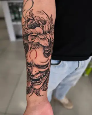 Tatuaż black and grey na przedramieniu: maska hannya z kwiatem piwonii, cieniowany realizm – SHADY TATTOO Wieluń
